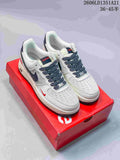Pair of white low-top sneakers with dark Swooshes, patterned laces, red accents, and a red box.