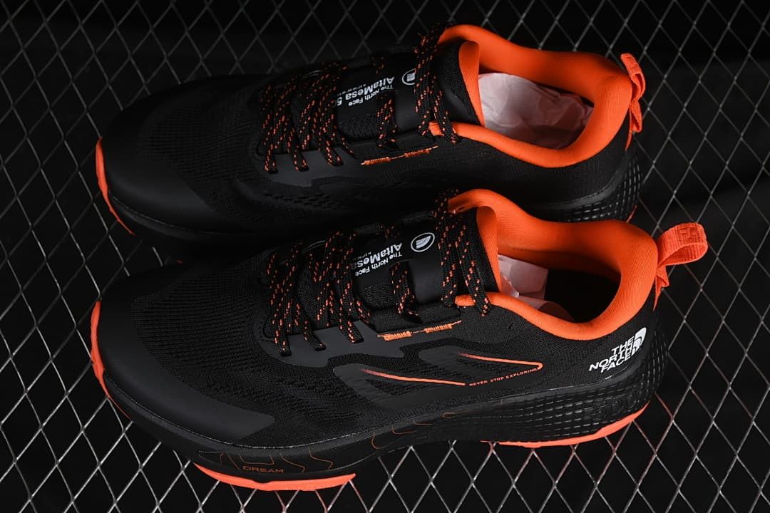 Pair of black and orange shoes shown from above and at the side.