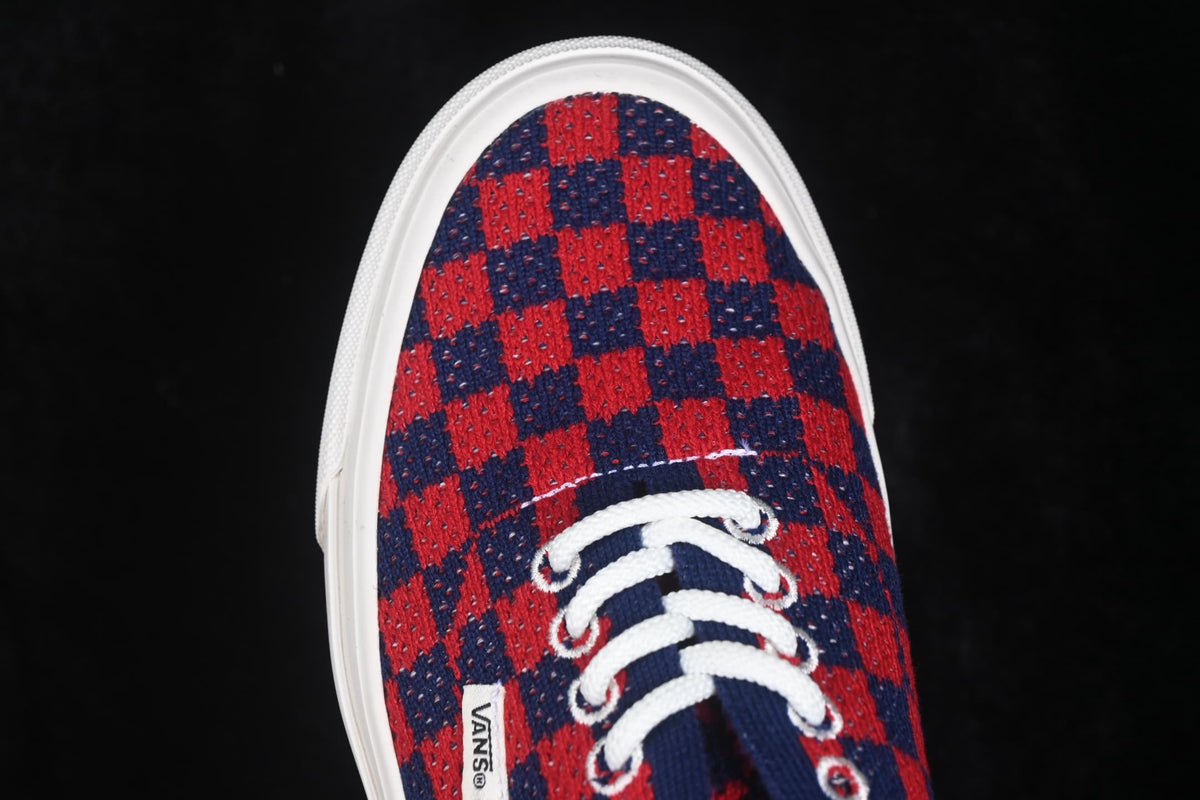 Close-up of the red and navy check-pattern toe box, white laces, and Vans side label.