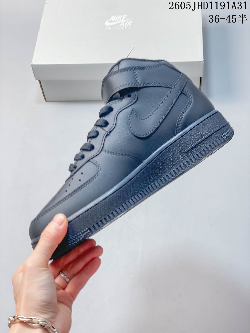 Side profile of a gray high-top sneaker with a tonal Swoosh and ankle strap