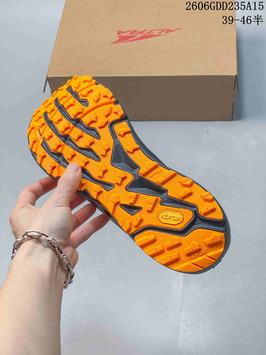 Close view of the orange lugged outsole, visibly marked Vibram.