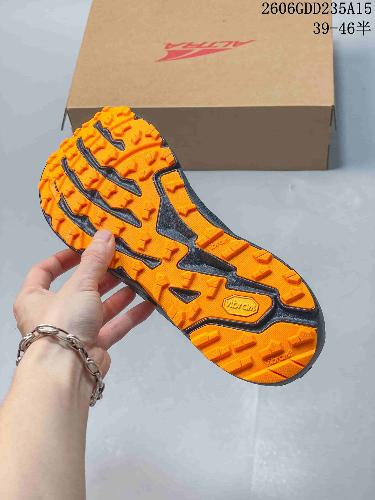 Close view of the orange lugged outsole, visibly marked Vibram.