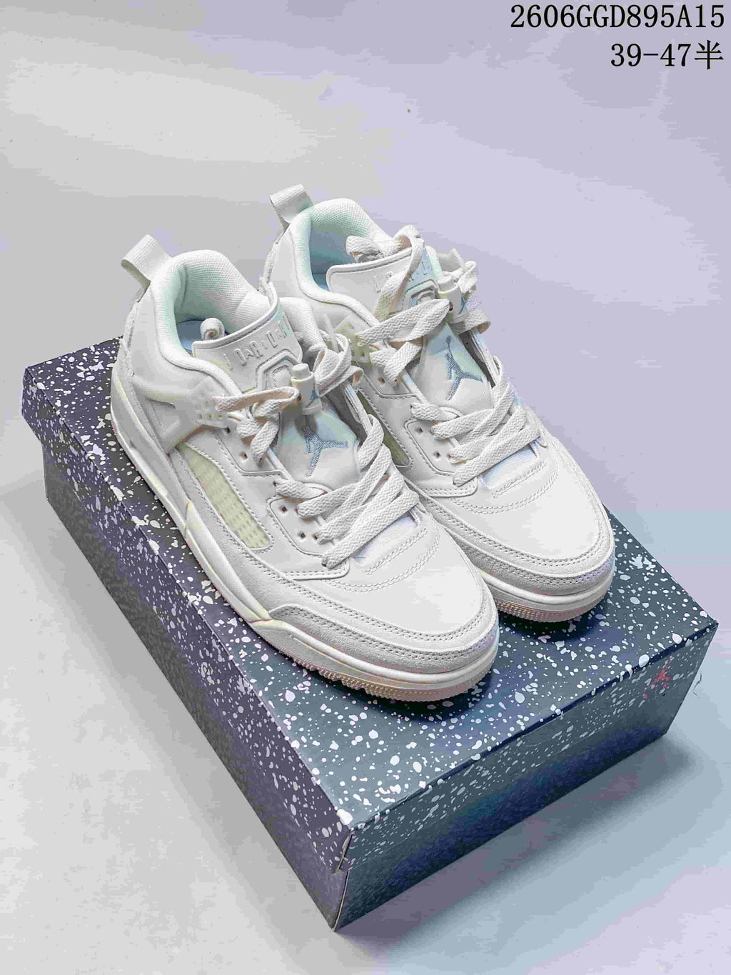Light-colored Jordan Spizike Low sneakers displayed on a speckled box
