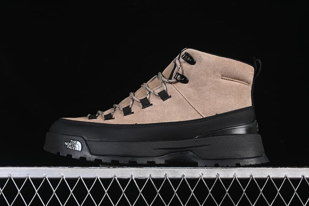 Side view of a brownish-black mid-cut boot with black overlays and a lugged outsole