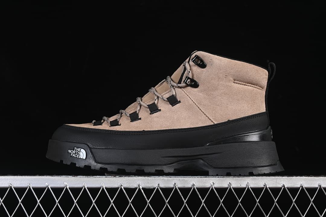 Side view of a brownish-black mid-cut boot with black overlays and a lugged outsole