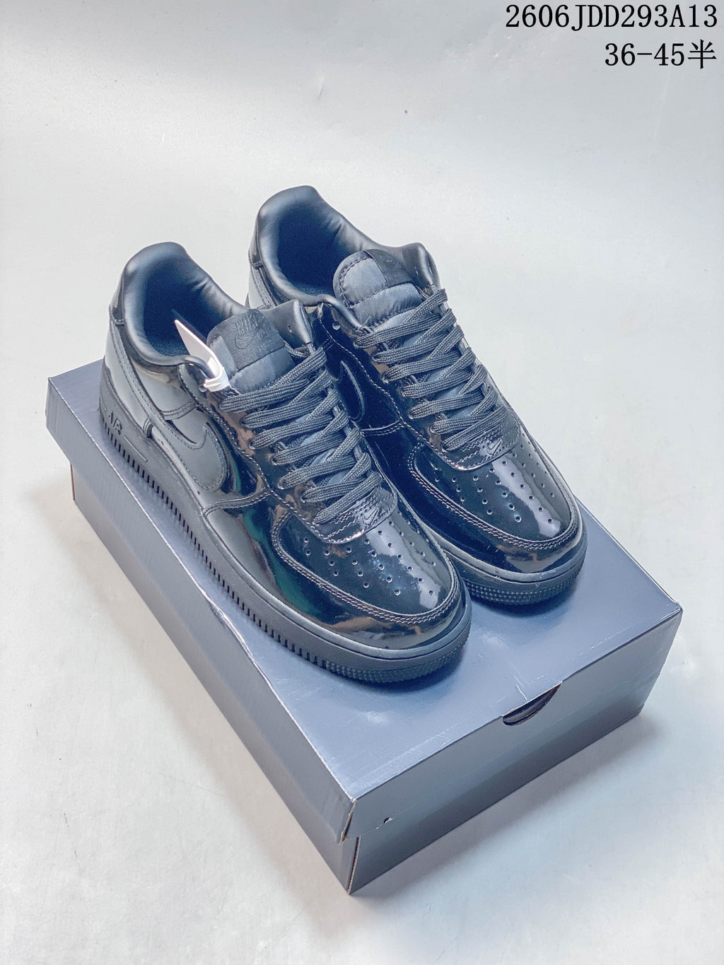 Pair of glossy dark low-top sneakers with perforated toes; image overlay shows size range 36–45.5.