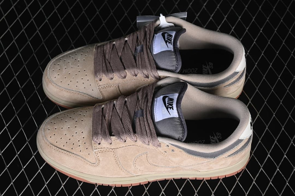 Overhead view of the pair of beige and grey Nike SB Dunk Low sneakers