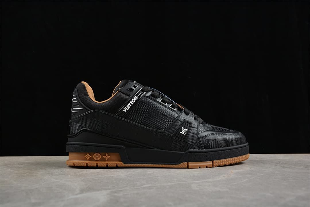Side profile of a black sneaker with logo details and a tan-colored outsole