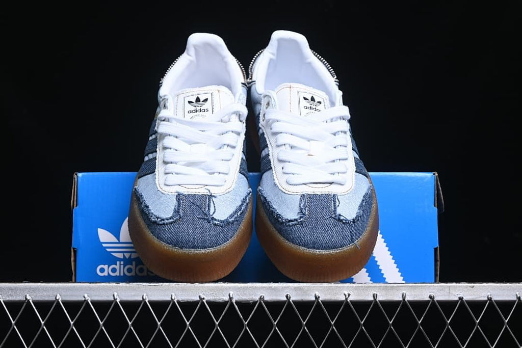 Front view of the pair displayed on a blue adidas shoebox