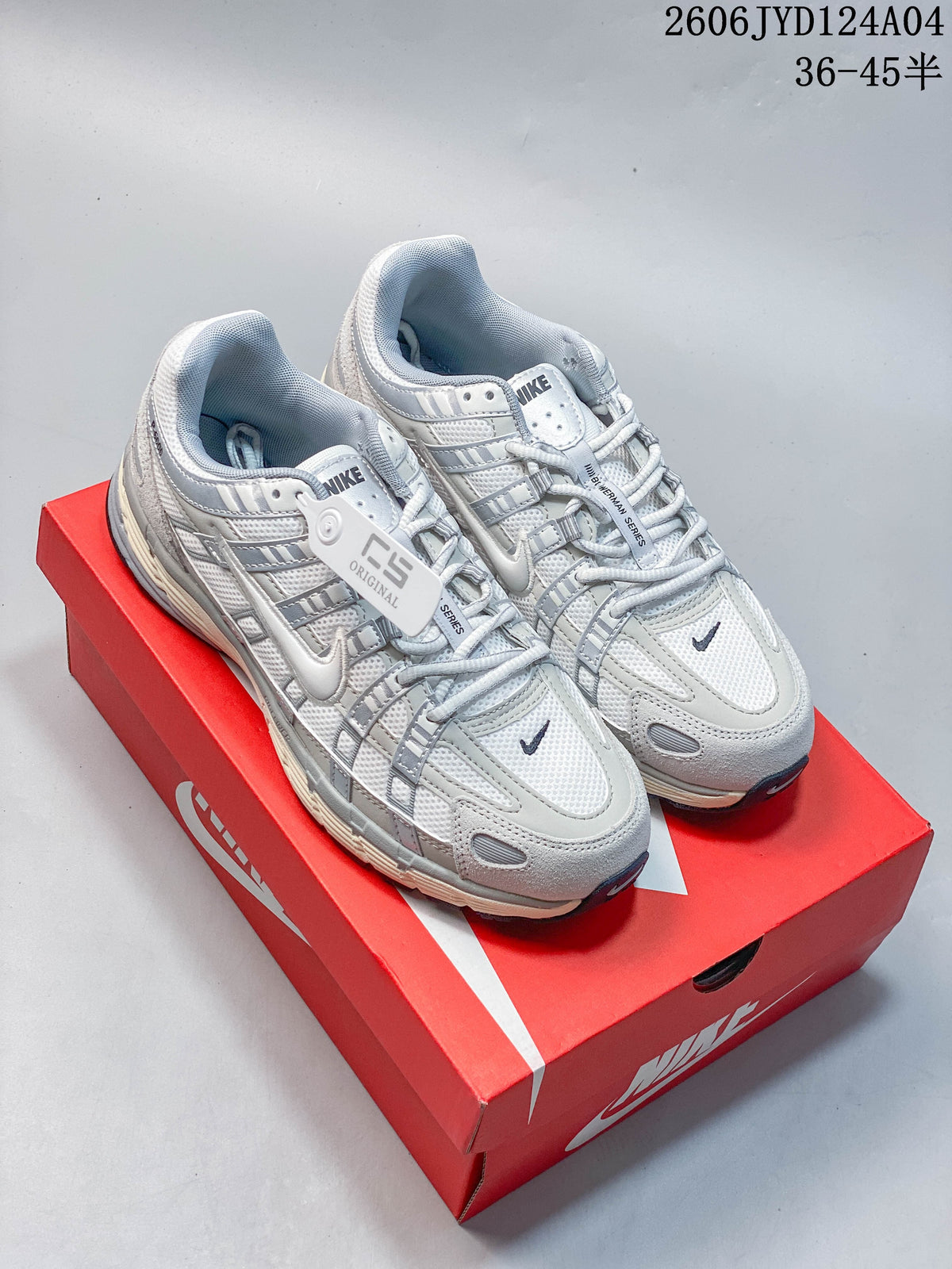 Pair of light gray and white Nike P-6000 sneakers shown on a red shoe box