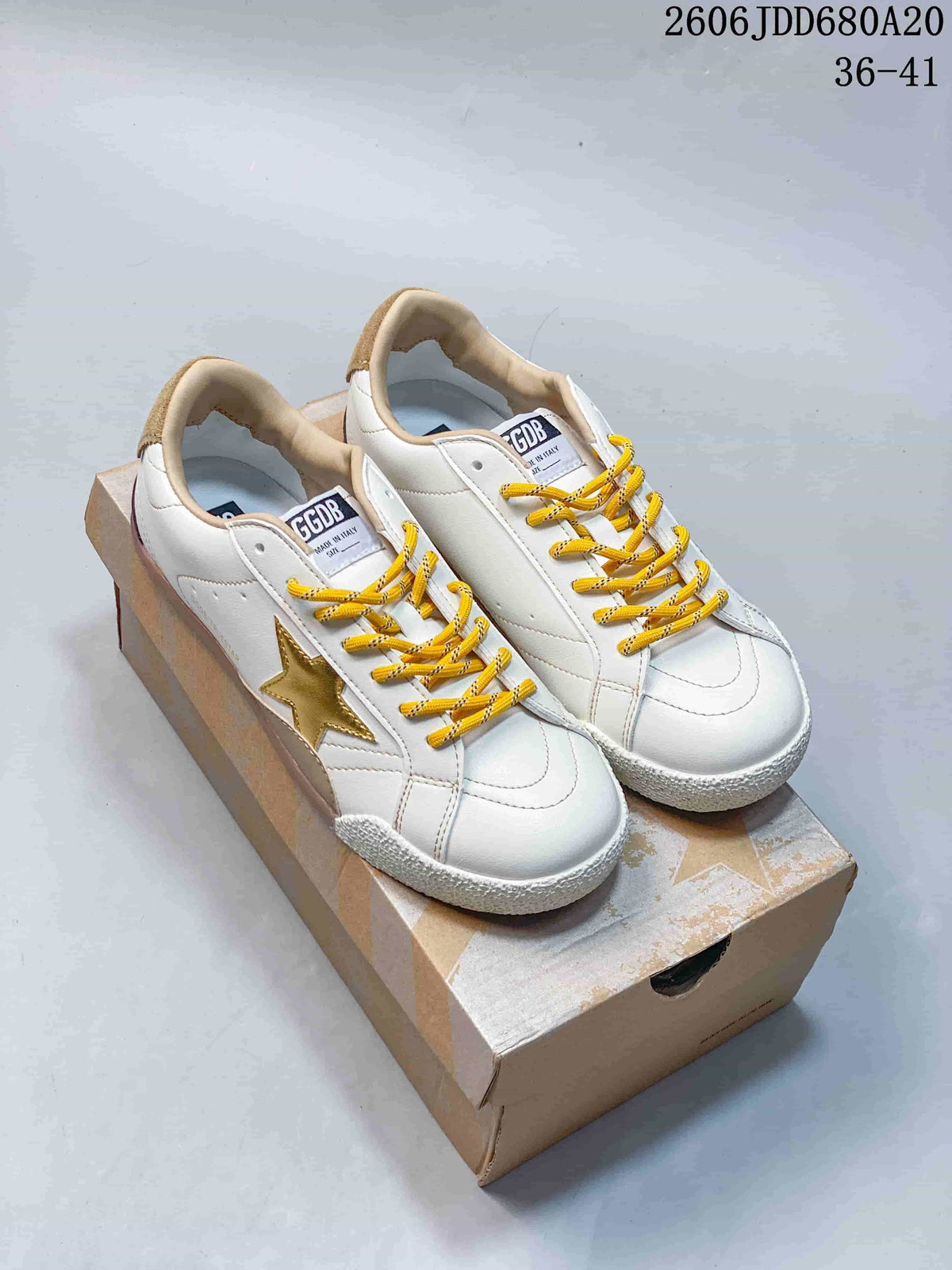 White Golden Goose Super-Star low-top sneakers with gold stars and yellow laces