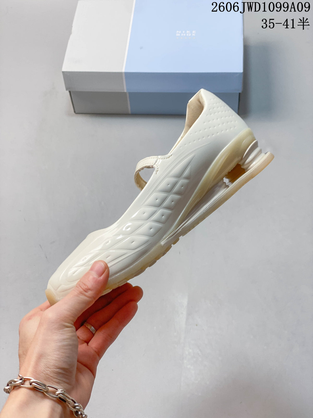 Side profile of an ivory Nike Shox Z Calistra sneaker with patterned panels