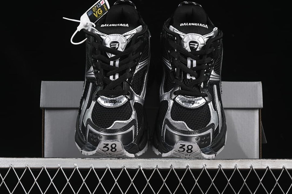 Front view of the pair showing black mesh uppers, silver accents, and size 38 markings.