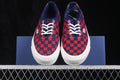 Pair of Vans low-top sneakers with a red and navy check pattern, white laces, and white soles shown from the front.