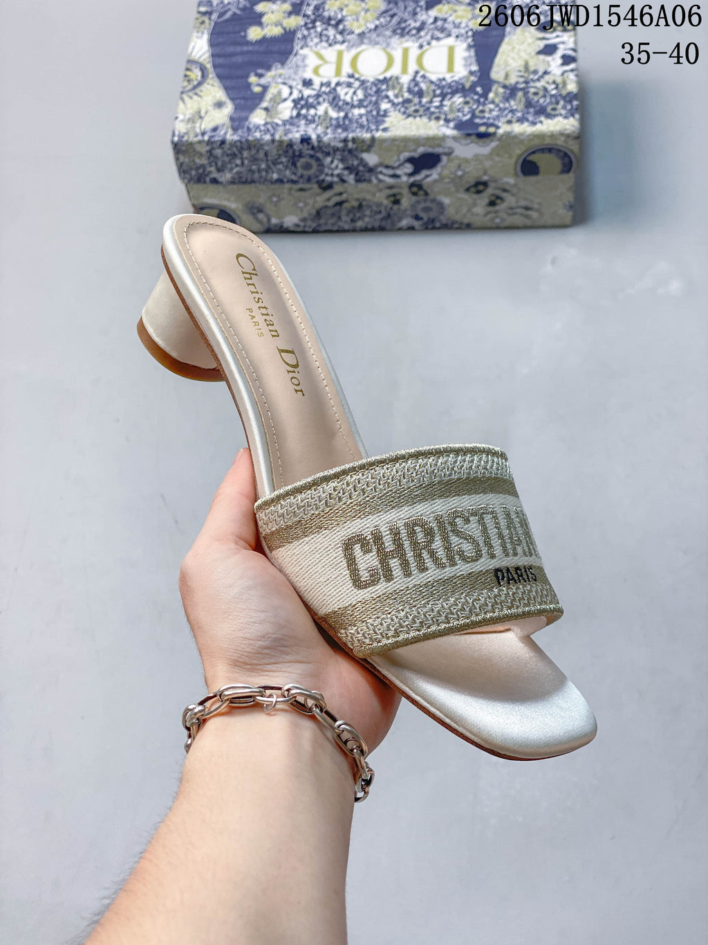 Angled view of a gold-toned embroidered mule sandal