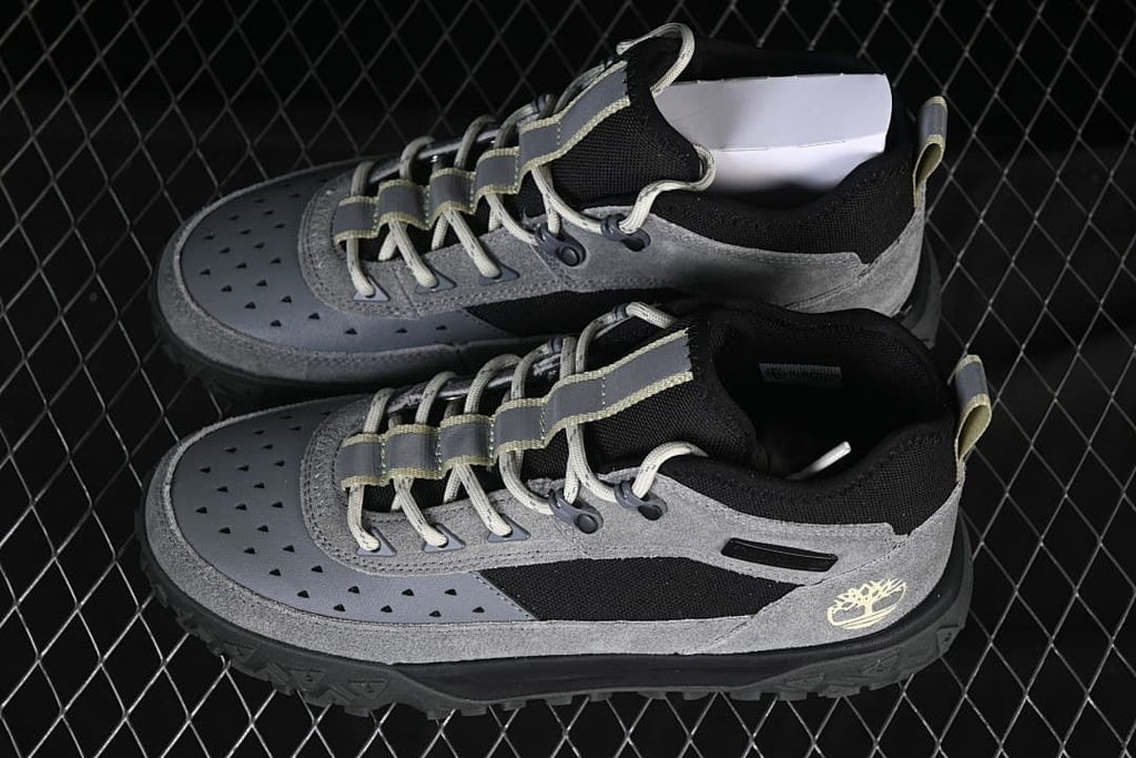 Pair of grey and black mid-cut lace-up sneakers shown from above and the side.