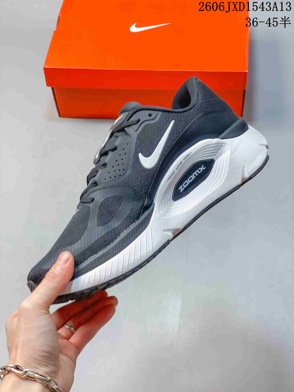 Side view of the charcoal Nike Structure Plus shoe with white Swoosh and midsole.