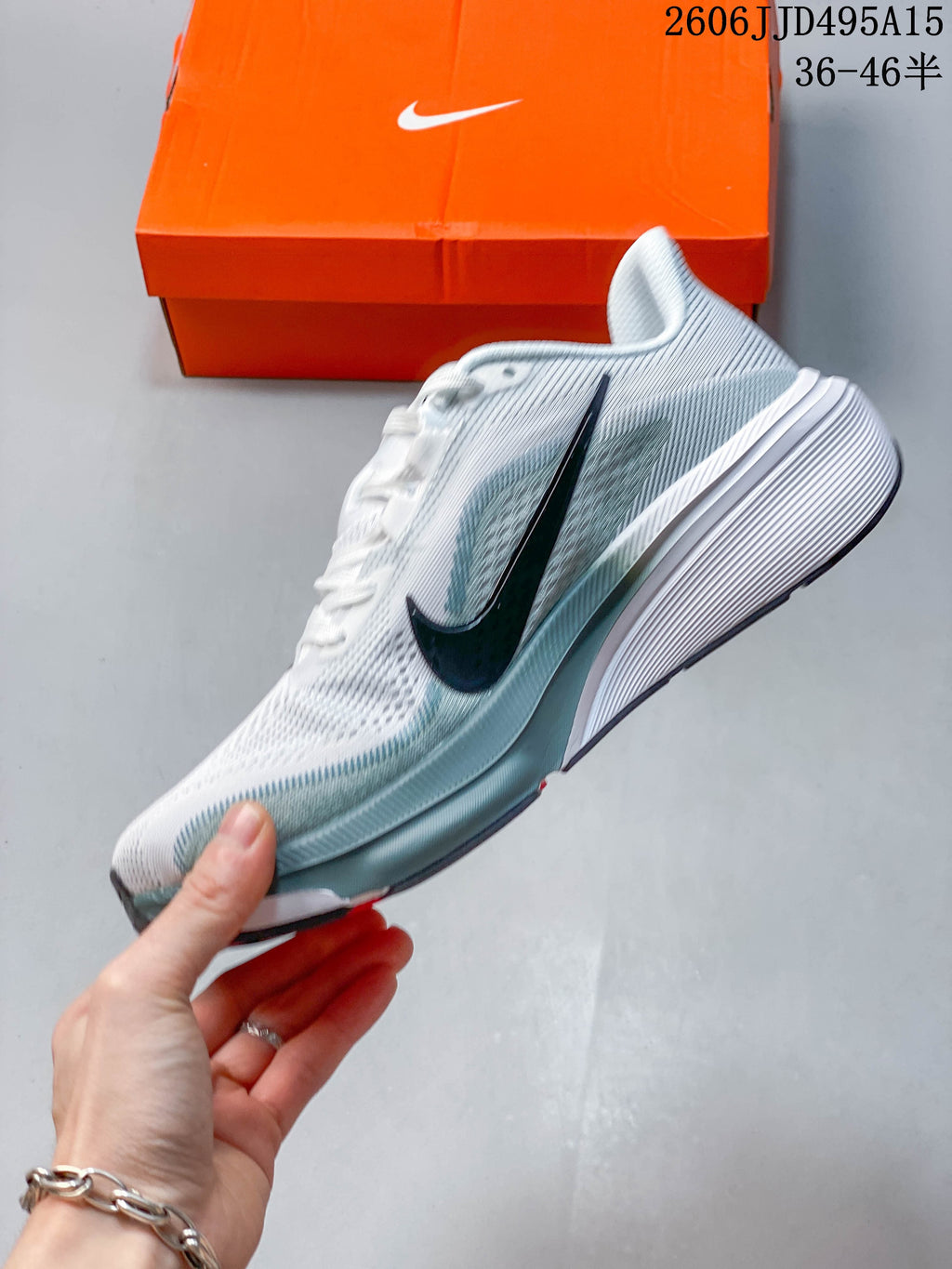 Side profile of a white and pale gray-green Nike Pegasus 42 running shoe