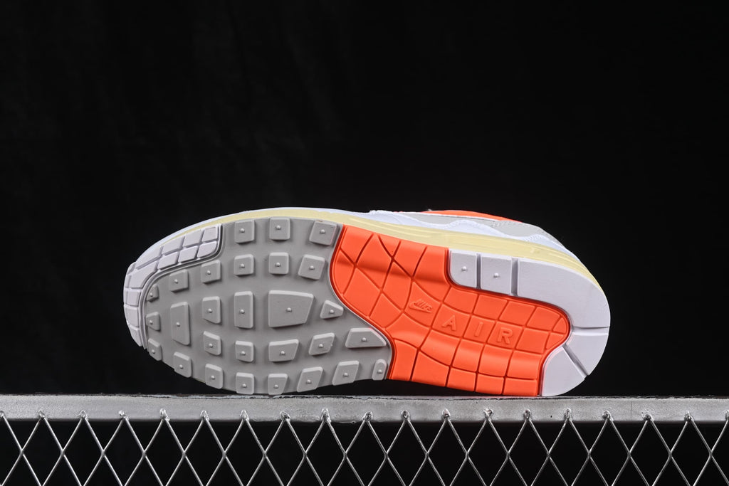 Underside view showing the grey and orange patterned rubber outsole of the Nike Air Max 1.
