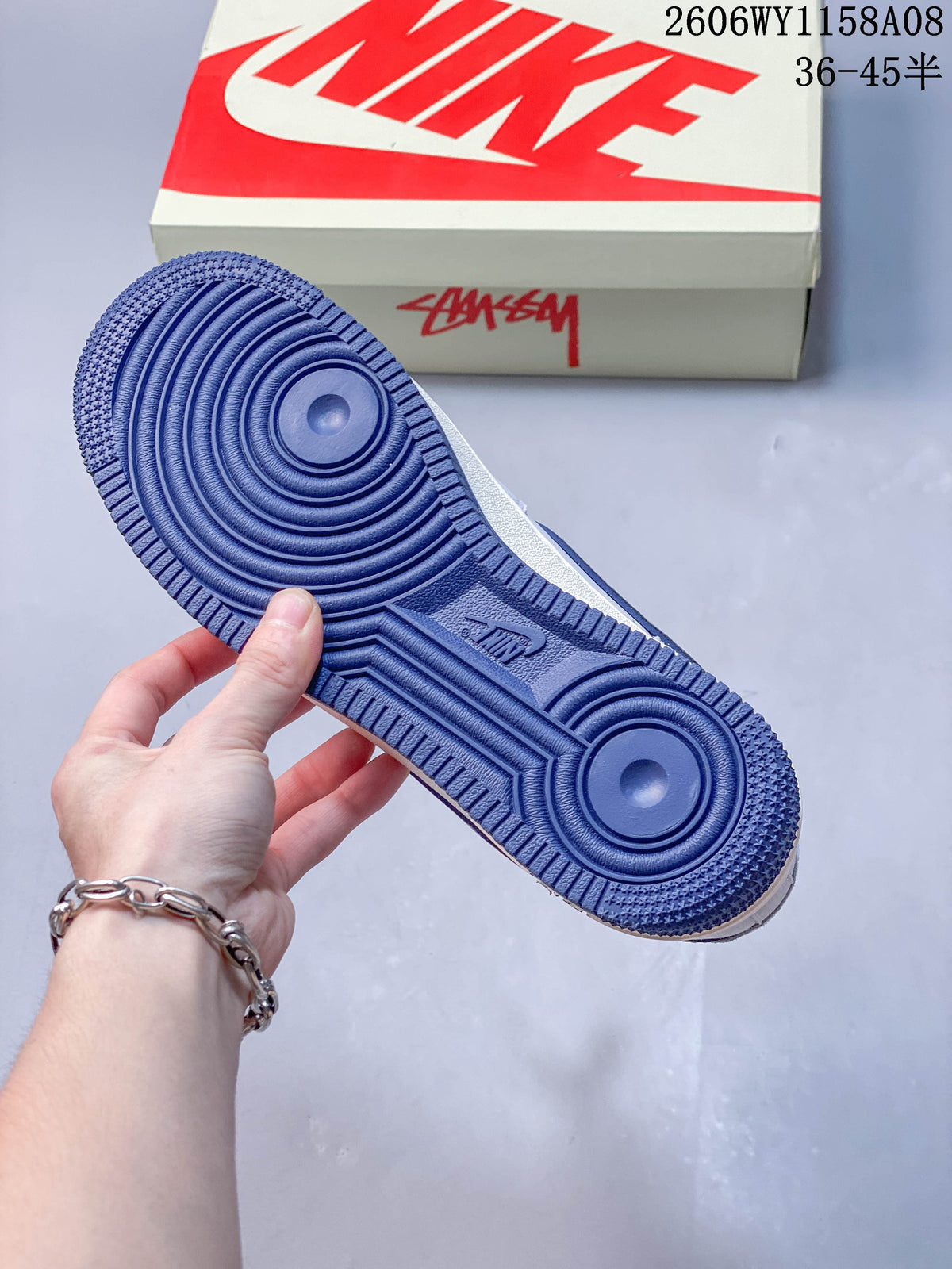 Blue outsole of a Nike Air Force 1 '07 sneaker with the shoe box in the background