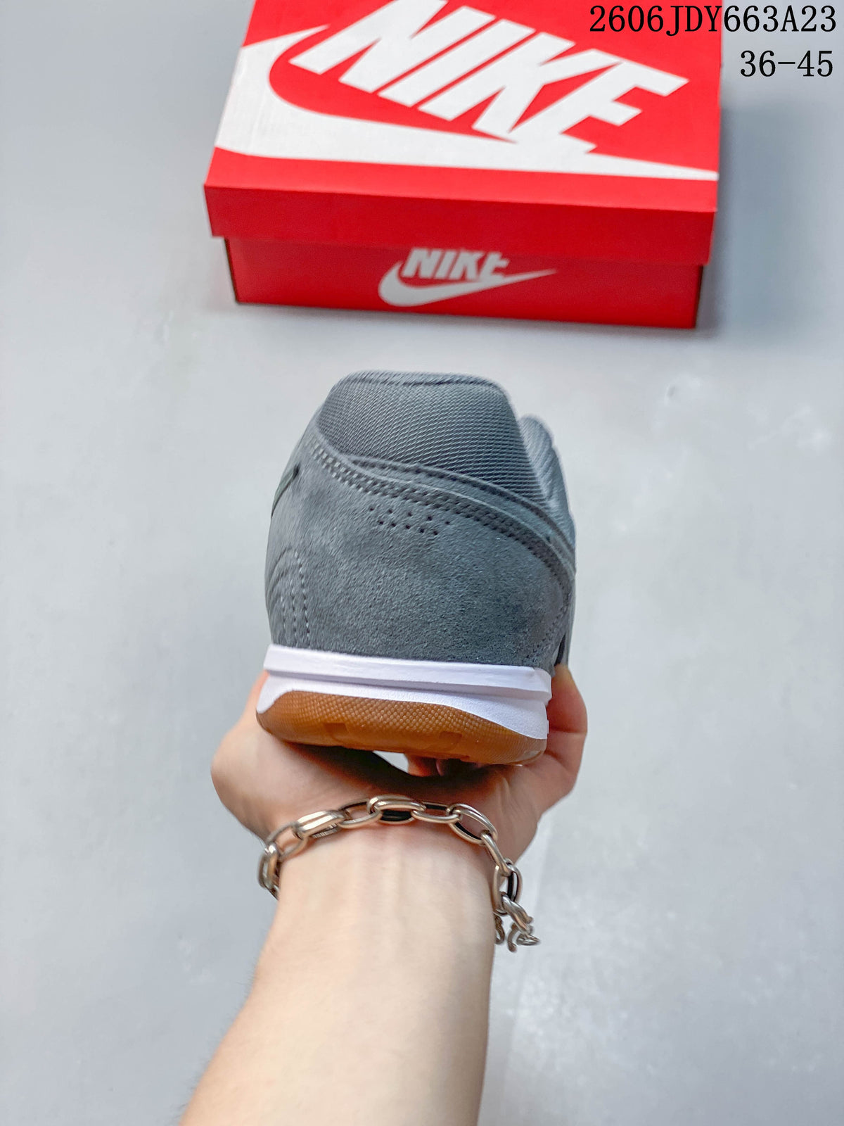 Rear view of a gray Nike Gato sneaker showing the white midsole and gum outsole