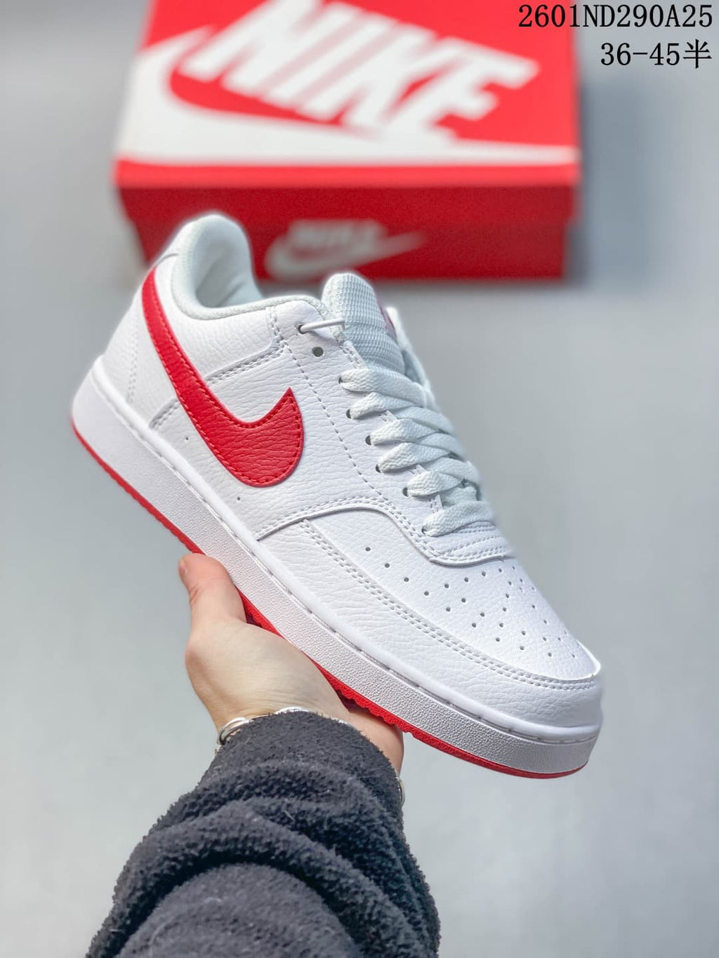 White low-top sneaker with red accents and perforated toe