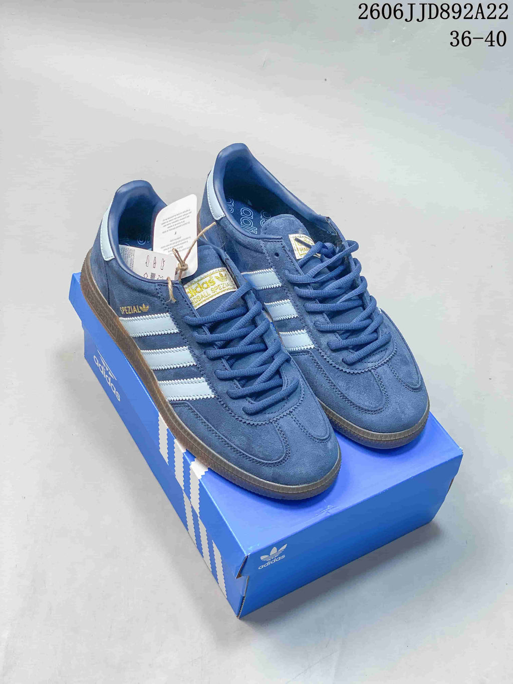Pair of blue adidas low-top sneakers with light-colored stripes and gum-colored soles