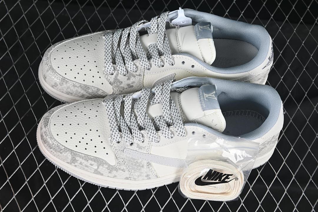 Top view of a pair of off-white and grey low-top sneakers with patterned laces and an additional set of light-colored laces.