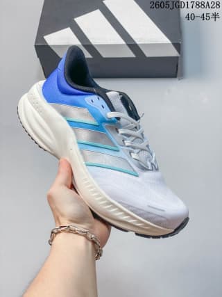 White training shoe with pale blue side stripes and a bright blue heel accent; box label shows 40–45.