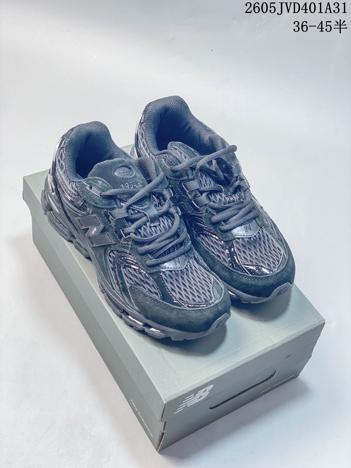 Dark charcoal New Balance 997 sneakers photographed on a shoebox