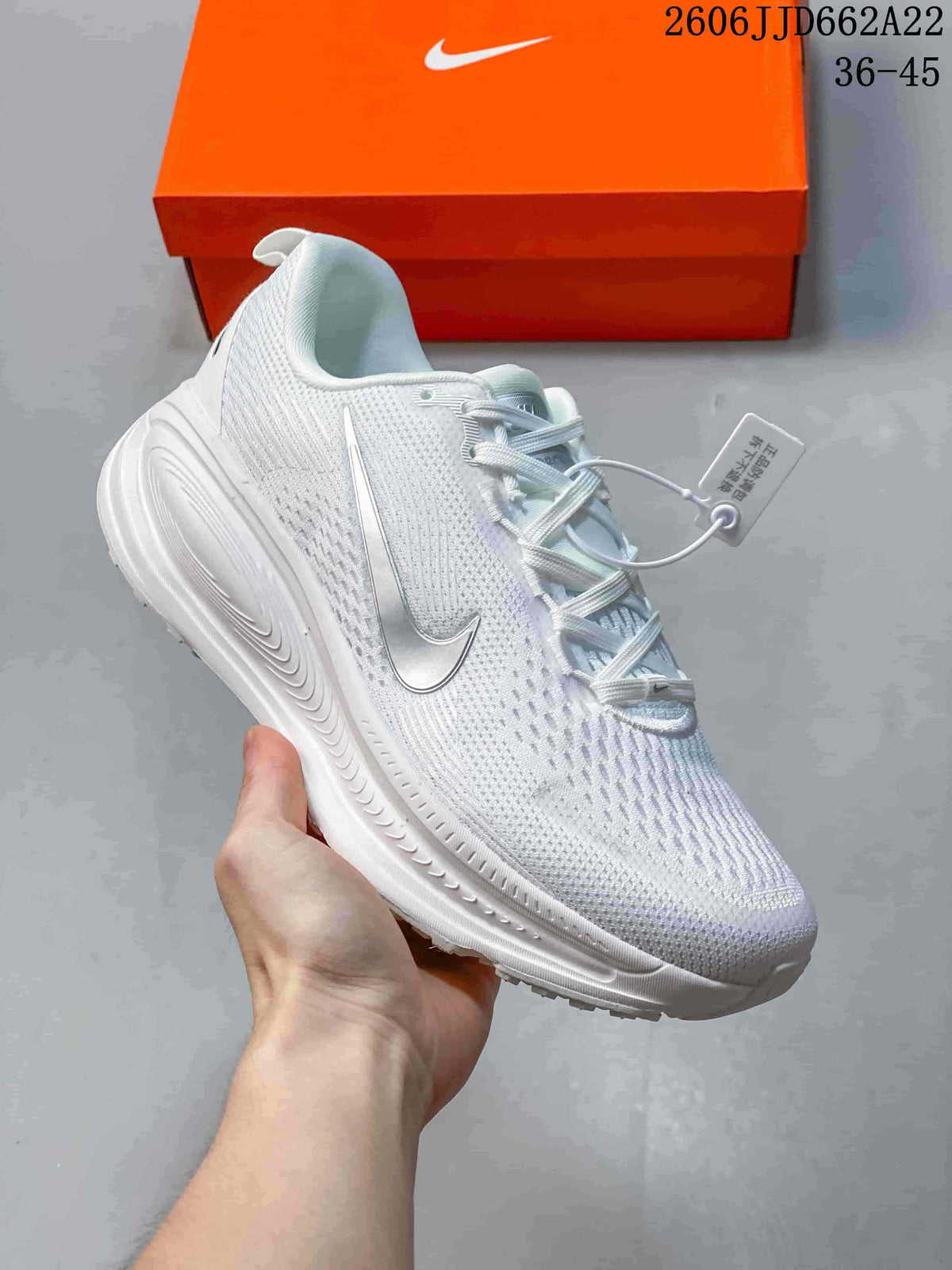 Side view of a white running shoe with a metallic-look Swoosh