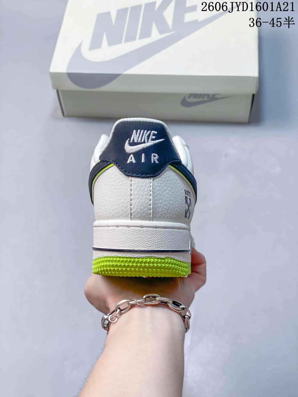 Rear view showing the sneaker's white heel, navy heel tab, and lime outsole