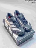 Pair of gray adidas Terrex trail running shoes with white stripes, shown on a shoe box
