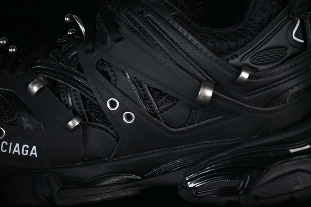 Close-up of layered black panels, eyelets and metal-tone details