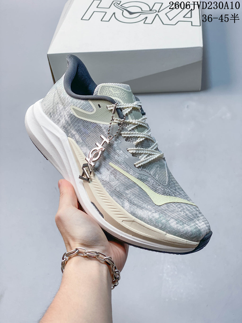 Angled side view of a grey HOKA Rocket X 3 shoe with pale accents and a white midsole.