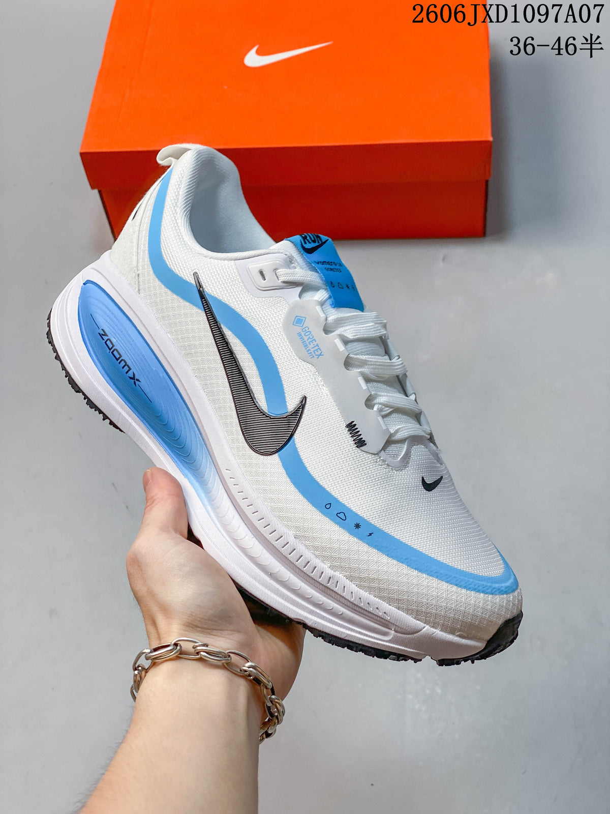 Angled side view of the white and blue shoe with visible Vomero styling