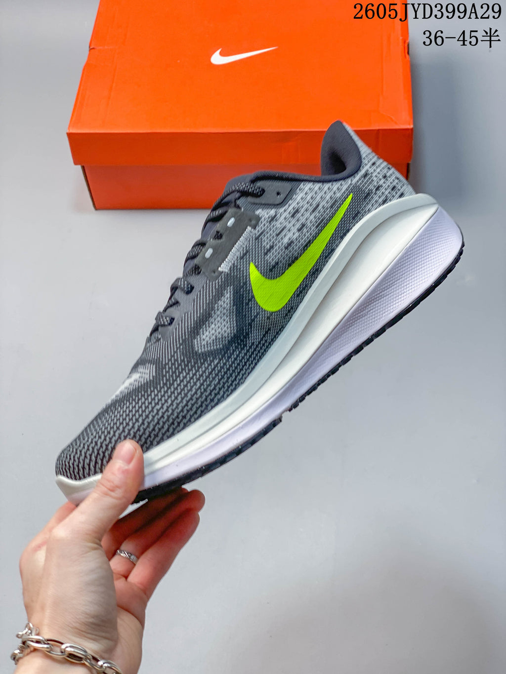 Side profile of a gray running shoe with a bright lime Swoosh and white midsole.