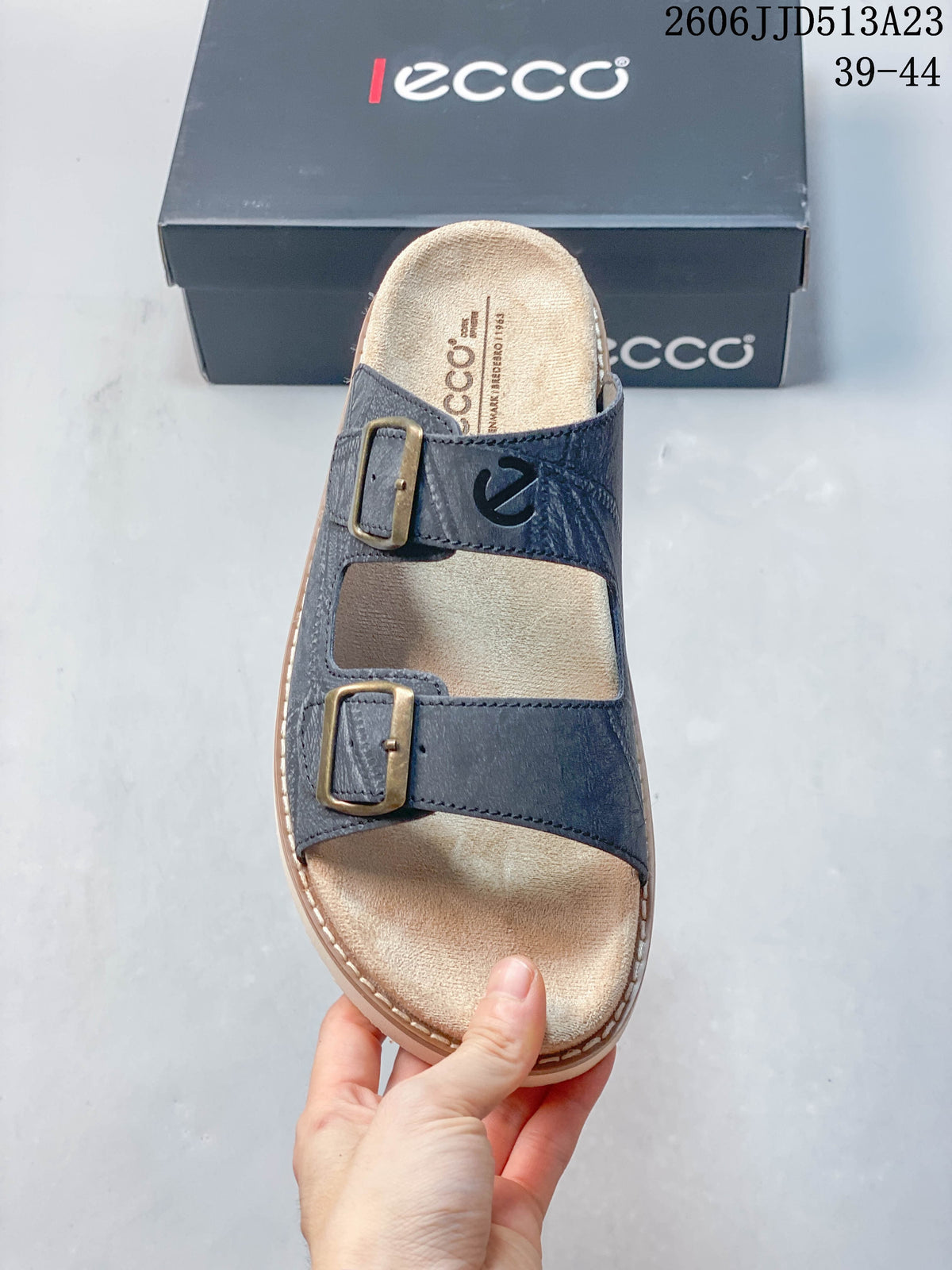 Top view of a slate-blue two-strap slide sandal with buckle details and a light footbed