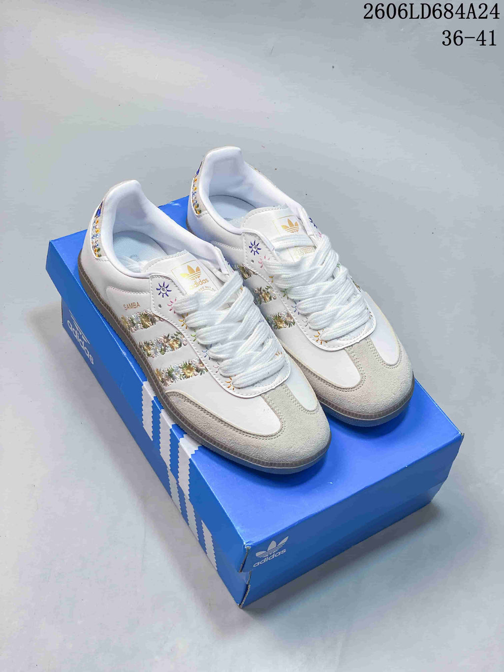 White Adidas Samba sneaker with multicolor floral details and three side stripes.