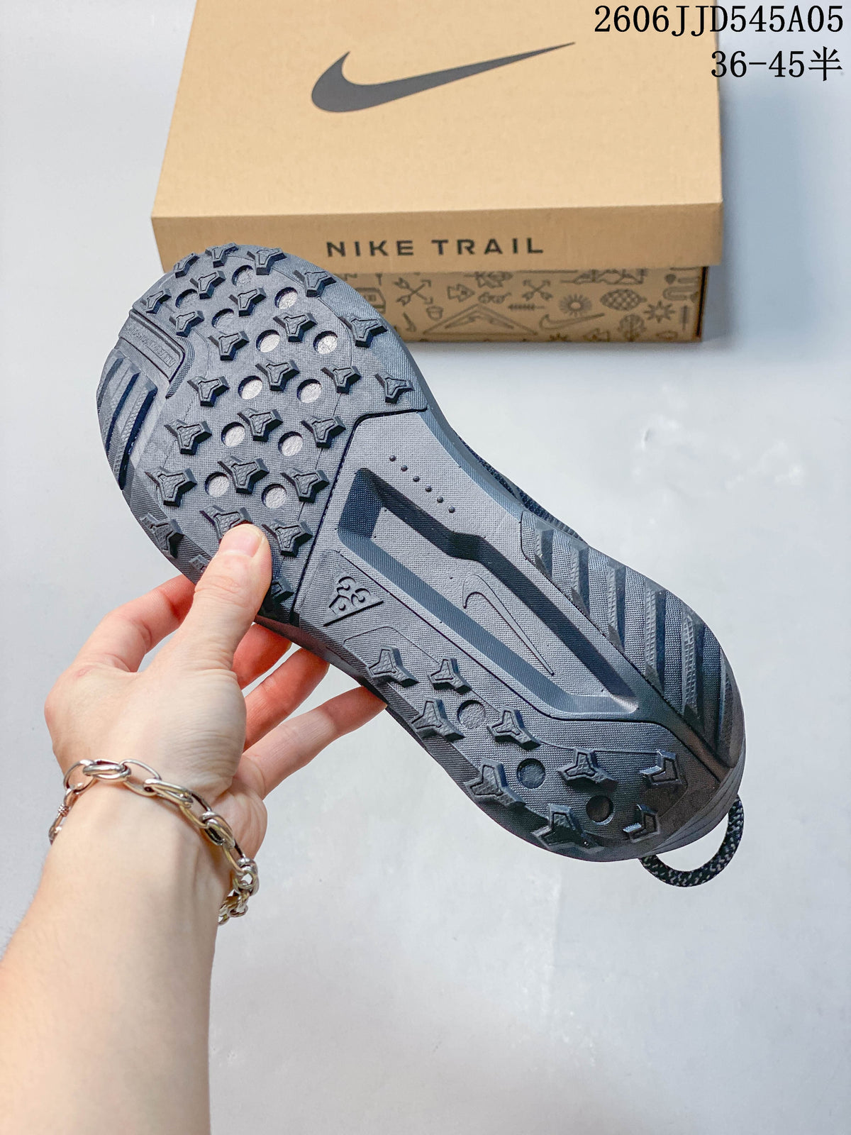 Close-up of the patterned outsole on a gray Nike Pegasus Trail 6 shoe