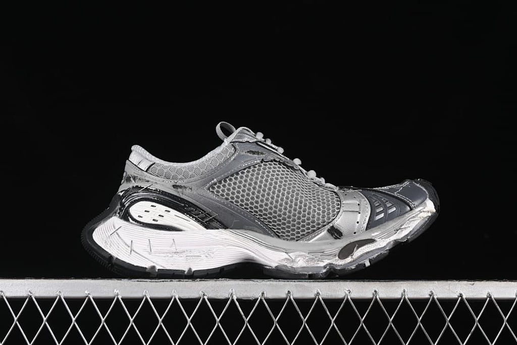 Side profile of the grey and silver sneaker with a chunky sculpted sole