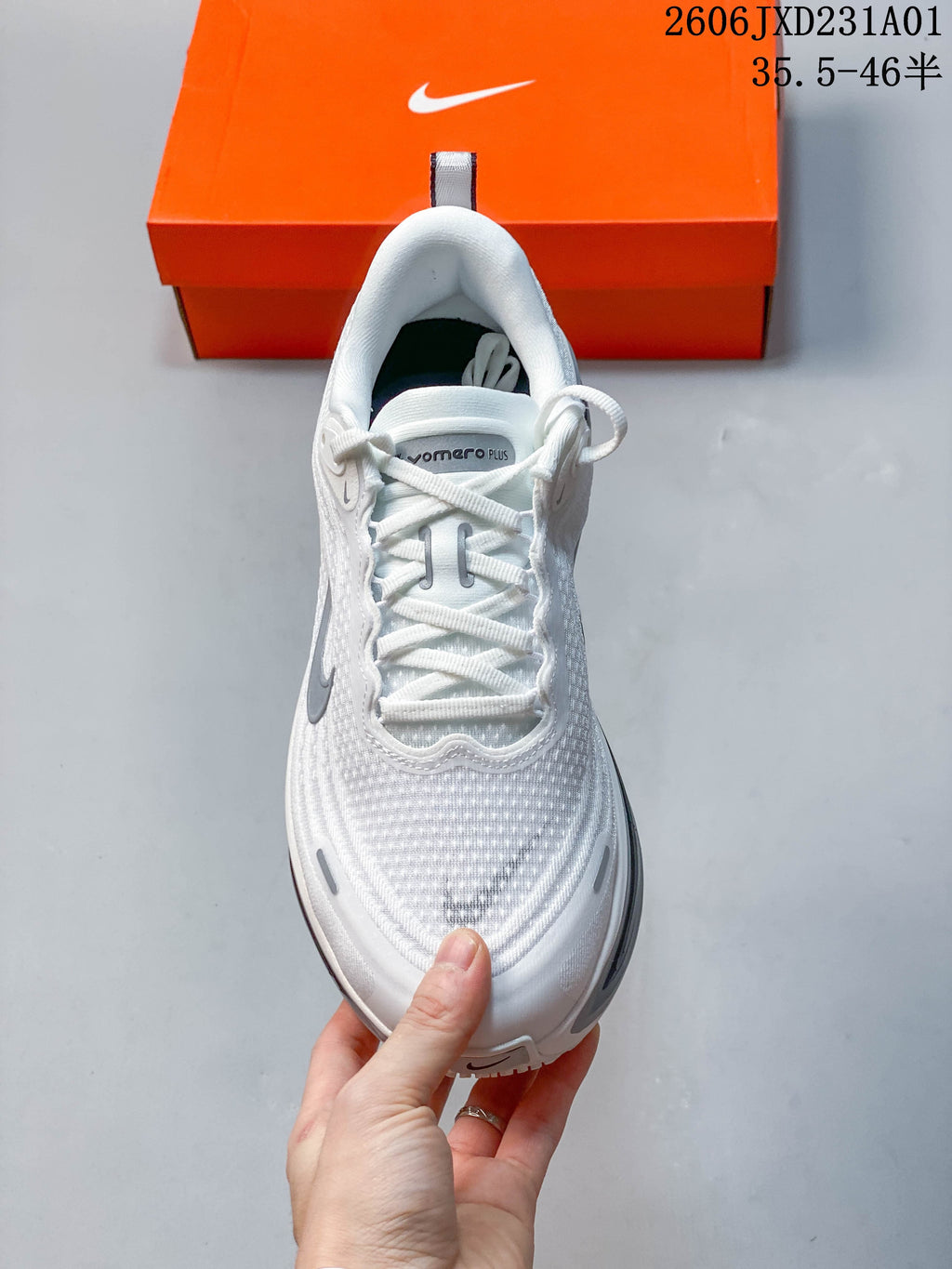Top view of a white Nike Vomero Plus shoe showing its laces and textured upper.