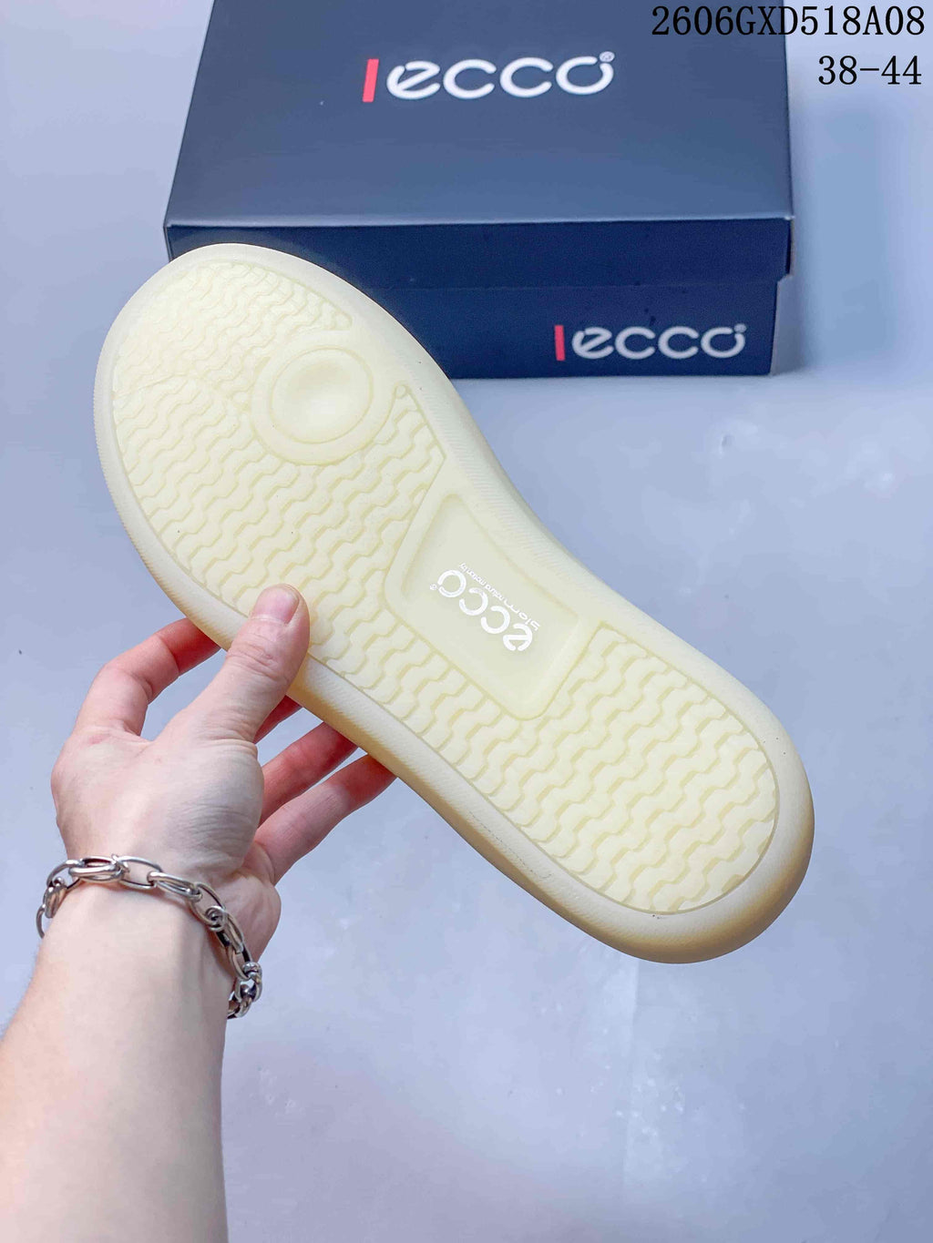 Underside of a pale sneaker outsole showing a patterned tread.