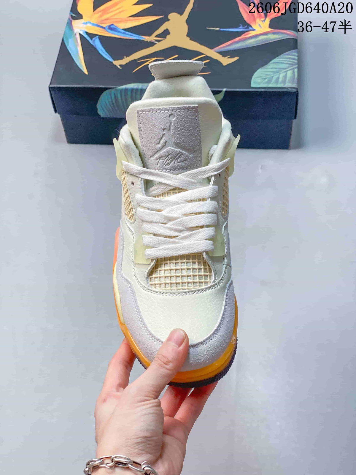 Front view of the beige Jordan Air Jordan 4 sneaker with mesh panels and gray accents