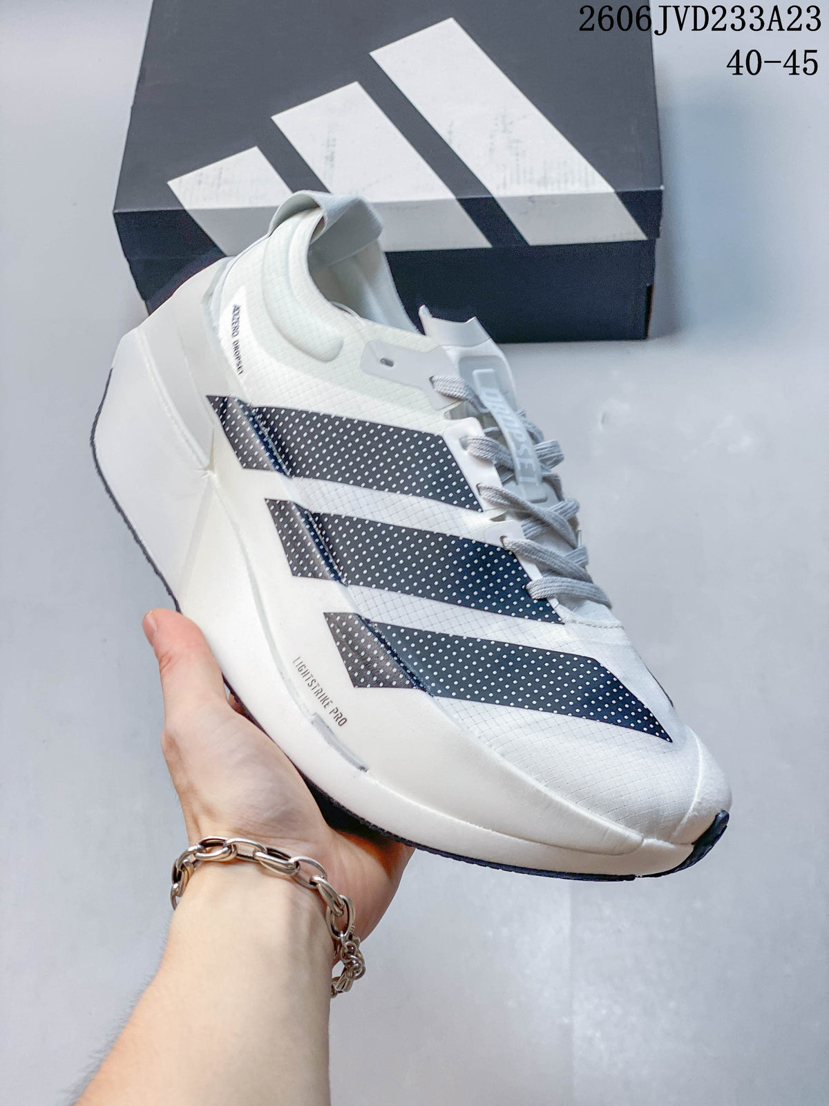 White Adidas Adizero Prime X3 running shoe shown from the side.