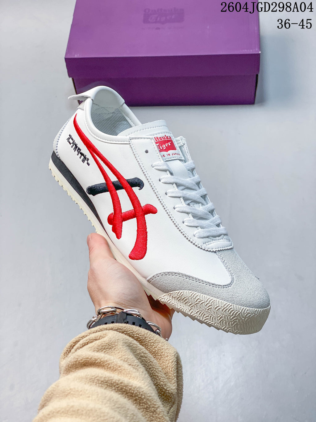 White Onitsuka Tiger Mexico 66 Deluxe sneaker with red side stripes and gray toe overlay.