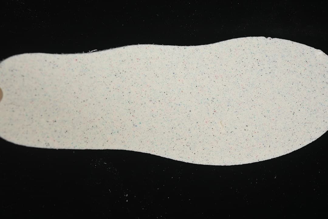 Close-up of a light-colored shoe insole with multicolor speckling