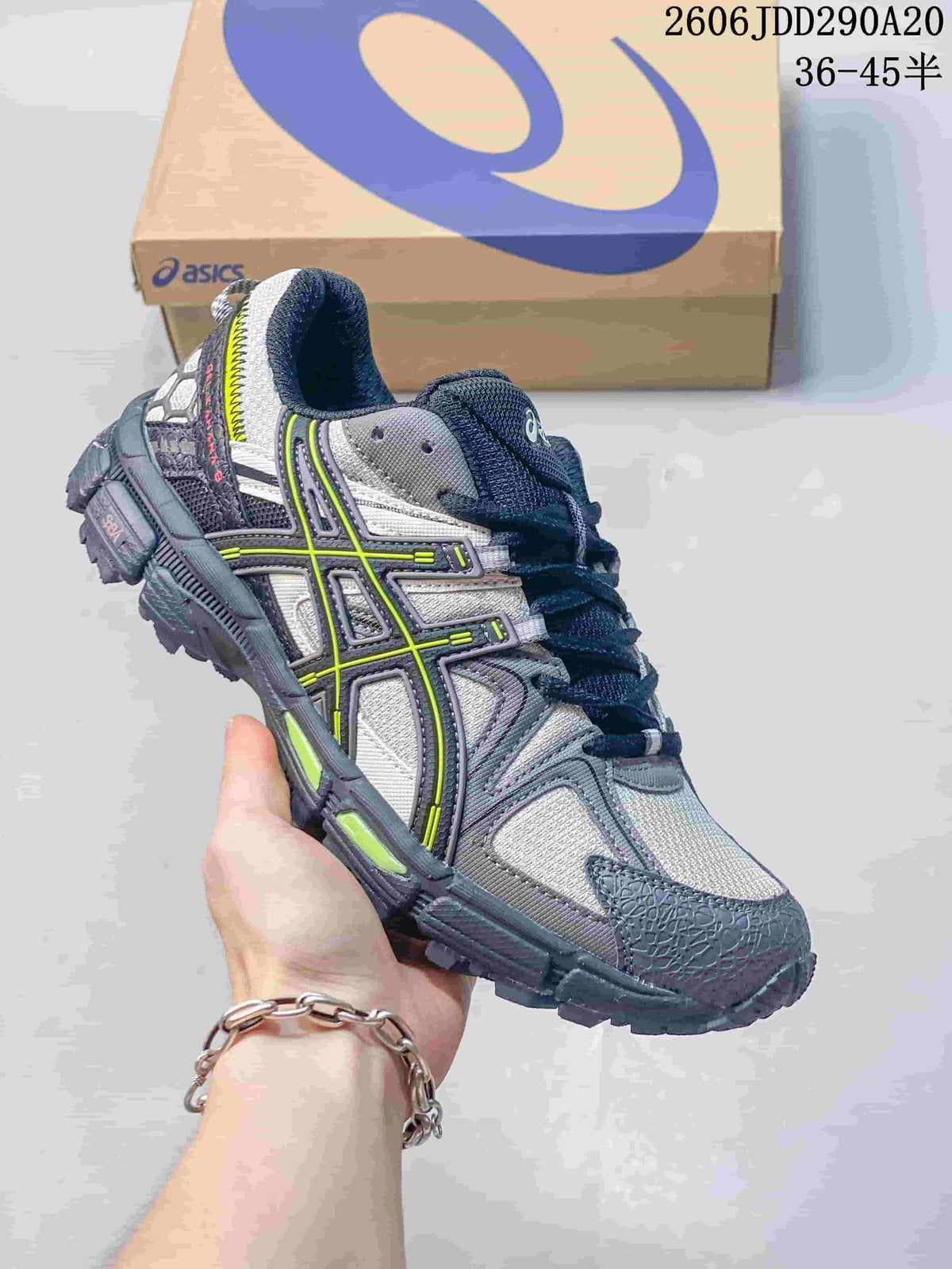 Close-up of a gray and navy ASICS Gel-Kahana 8 sneaker with bright yellow-green accents.
