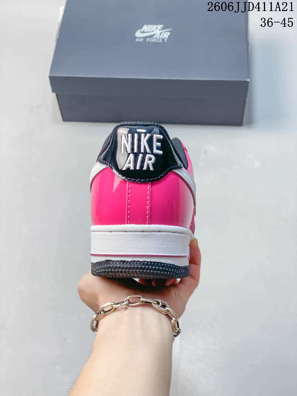 Rear view of a pink Nike Air Force 1 sneaker with white midsole and dark heel tab