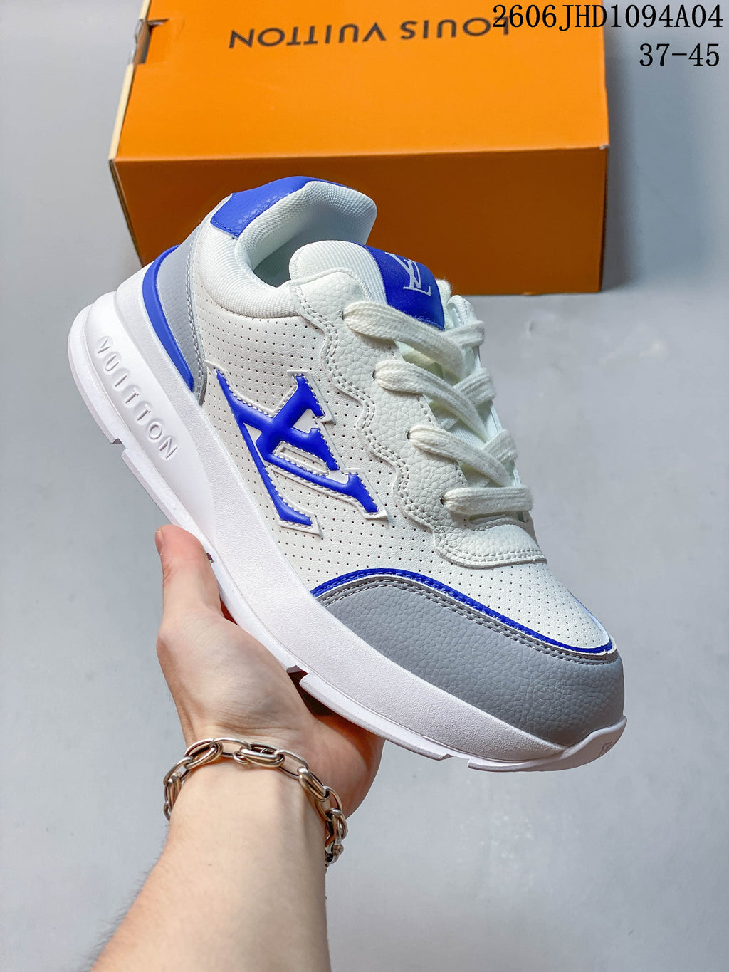 White low-top Louis Vuitton Trainer sneaker with blue accents and a gray toe panel